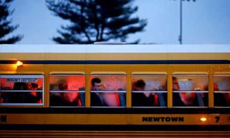 People arrive on a school bus at Newtown High School for a memorial vigil after the 2012 Sandy Hook shooting.