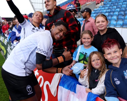 Fiji players sign autographs for fans after their game against Scotland in Salford.