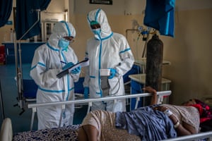 Medical staff take a patient’s temperature before testing her for coronavirus at De Martini hospital.