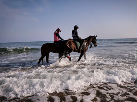 Jennie Durrans and Minella Study (right) cool off alongside a stablemate in the water at Bamburgh beach