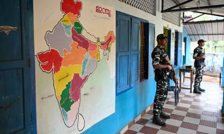 Security personnel guard a polling station in the Wayanad district of Kerala state, southern India