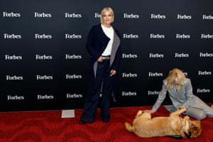 Judith Light sits on the red carpet stroking a dog who has rolled on to its side. Selma Blair is posing for a photo with her hand in her pockey