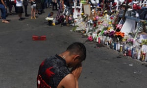 A man prays at a memorial three days after a mass shooting at a Walmart store in El Paso, Texas.