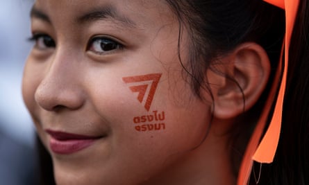 A young girl with a temporary tattoo of the logo of the Move Forward Party smiles at a rally to celebrate the Thailand general election result