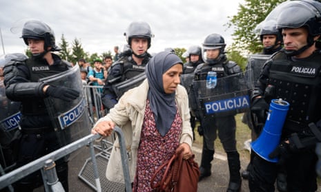 Slovenian police allow refugees to enter the country through the border crossing in the Croatian village of Harmica.