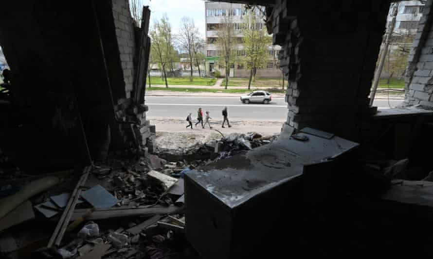 People pass by a heavily damaged residential building in the northern Ukrainian city of Chernihiv.