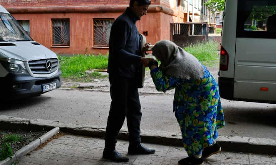 A man helps an old woman to get on an evacuation bus from Kramatorsk to Dnipro