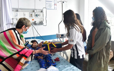 Colombia's first lady Veronica Alcocer (left) and Sofia Petro (right), the daughter of President Gustavo Petro, visit one of the four children in hospital