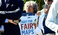 woman holds sign saying fight for fair maps
