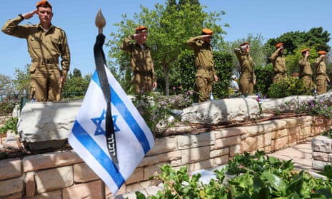 Israeli soldiers salute during a ceremony before the country's memorial day for fallen soldiers and victims of attacks.