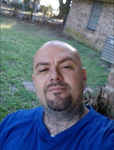 Um homem vestindo uma blusa azul com decote em V posa para uma selfie ao ar livre