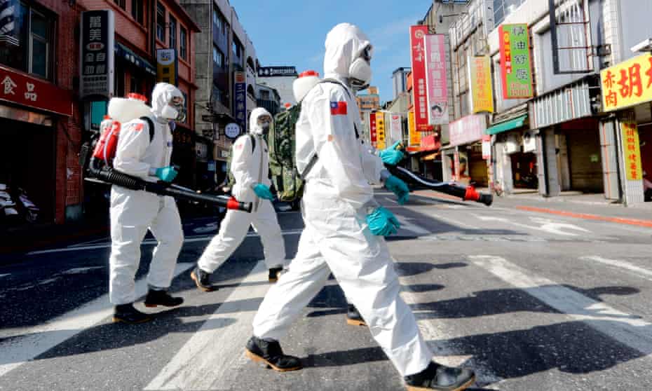 Troops disinfect public areas of Wanhua district in Taipei. A minister has angered young people by accusing them of complacency about the virus.