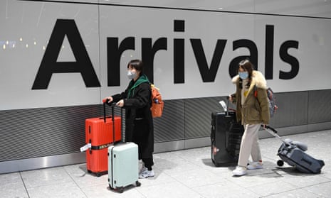 Passengers in face masks arrive at Terminal 5 of London Heathrow airport