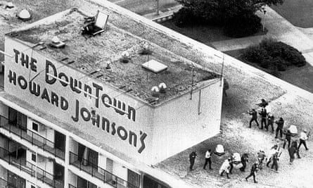 New Orleans police officers fire into a concrete cubicle atop the Howard Johnson hotel, where Mark Essex was holed up.