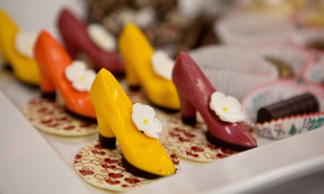 A white platter holds candies shaped like red, yellow and orange high-heeled shoes.