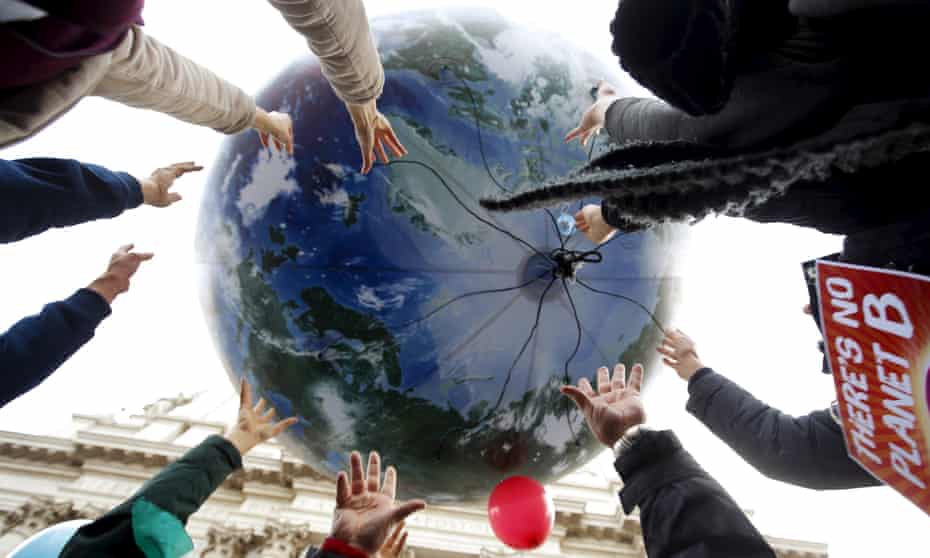 Climate protesters wield a globe-shaped balloon during a rally at the start of the 2015 Paris World Climate Change Conference