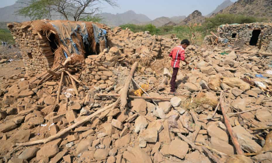 A boy walks on the rubble of houses destroyed by Saudi-led airstrikes in Yemen