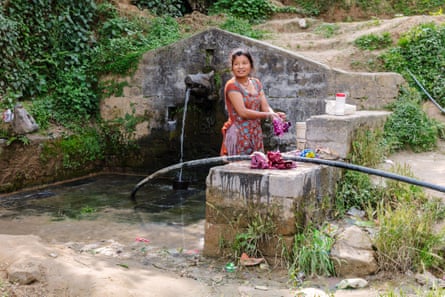 A young woman washes her clothes in a spring in Dhulikhel, Nepal.