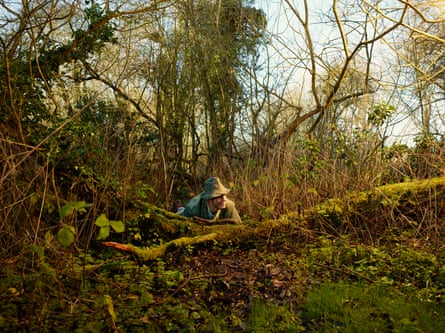 Charles Foster crouching in woodland.