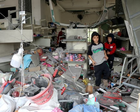 Children walk through a damaged shop as displaced residents return to the southern Lebanese village of Srifa on Sunday.