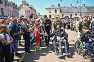 The US veteran Mel Jenner shakes hands with onlookers in the streets of Sainte-Mère-Église, north-west France