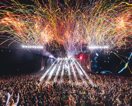 A large crowd of people with a stage and lights in front