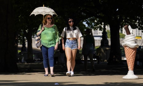 People shelter from the sun on the South Bank in London on Monday
