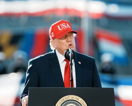 Man in suit and red hat at lectern