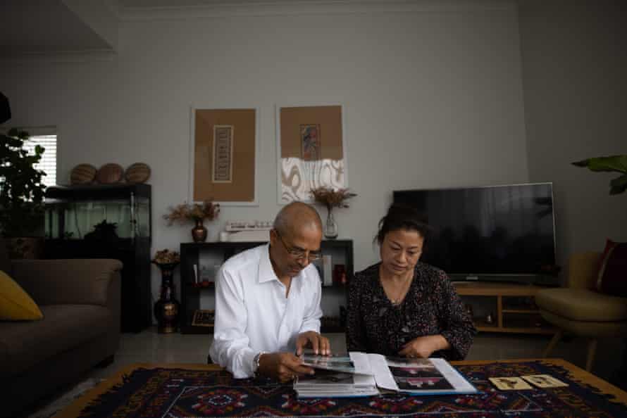 Om Dhungel and his wife, Saroja, looking at old photos of their time in Nepal.