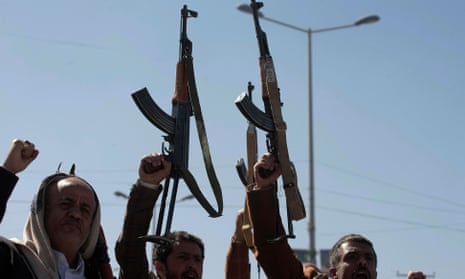 Newly recruited Houthi fighters hold up a weapons in a ceremony at the end of their training in Yemen.  