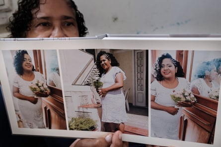 a woman holds a photo album displaying pictures of another woman