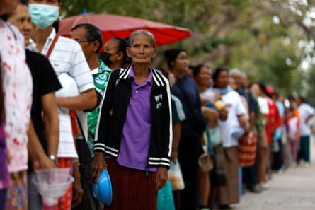 Displaced Thai villagers wait for food distribution at a school.