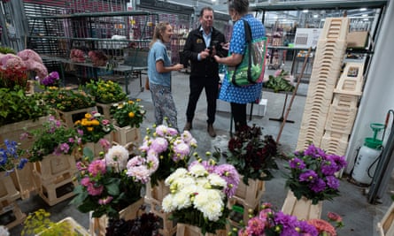 A flower stall holder chats to customers.