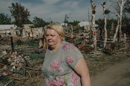Inna Valentinova walks past the ruins of a house