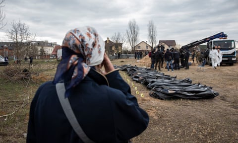 Natalia Lukyanenko watches as authorities excavate a mass grave in the grounds of the Church of Andrew the Holy Apostle in Bucha. 
