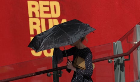 A racegoers shelters from the rain.