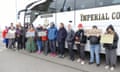 A line of people, mostly young, stand in front and down the side of a coach, some holding handpainted cardboard signs reading Block The Barge, Hands Off Our Community, Margate 4 Migrants, No Human is Illegal and Keep the Unity in Community
