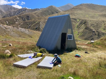 Liam, 5, and James Bell, 7, wipe down mattresses at the A-Frame Hut
