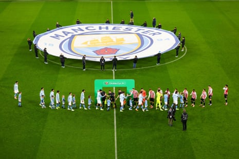 The players shake hands in front of a Carabao branded arch.