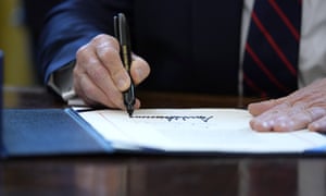 Donald Trump signs the coronavirus stimulus relief package in the Oval Office. He has insisted on his name appearing on all stimulus checks being sent out to taxpayers.
