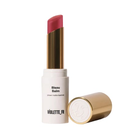 A Violette FR Bisou Balm. The lipstick style tube has some of the Rose Latte balm visible. The lid is next to the tube.