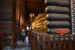 Tourists take a selfie in front of the reclining Buddha at Wat Pho