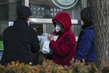 Residents line up to buy cold and fever medicine at a pharmacy in Beijing.