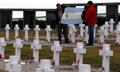 Falklands war veterans display an Argentine flag as they pay homage to Argentine soldiers who died during the conflict at Darwin cemetery in the Falkland Islands.