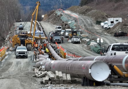 a section of pipeline is assembled, surrounded by several work trucks