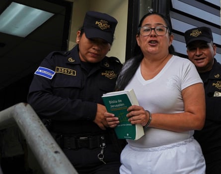 Ruth Lopez holding green bible with police at court