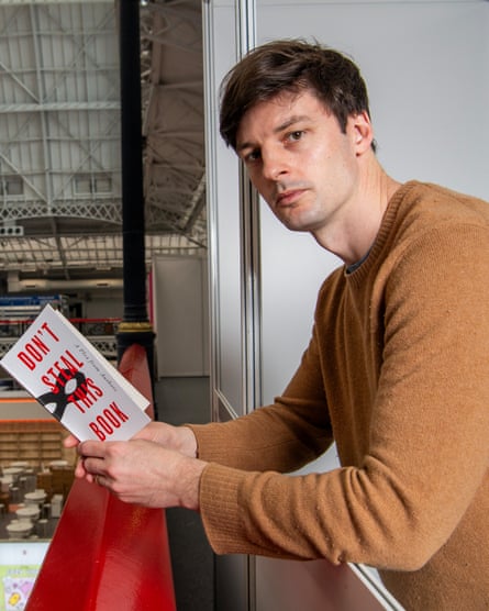 Ed Newton-Rex poses while holding the book