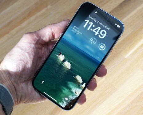 Apple iPhone 15 review in a hand showing the new iOS lockscreen.