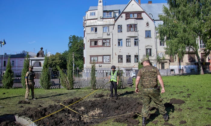 Policemen inspect the scene after shelling hit the premises of the National University of Urban Economy in Kharkiv, north-eastern Ukraine