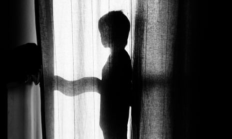 Boy standing behind a curtain.